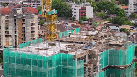 skilled construction workers at work: time-lapse of building the next level on a rooftop of a large urban high-rise