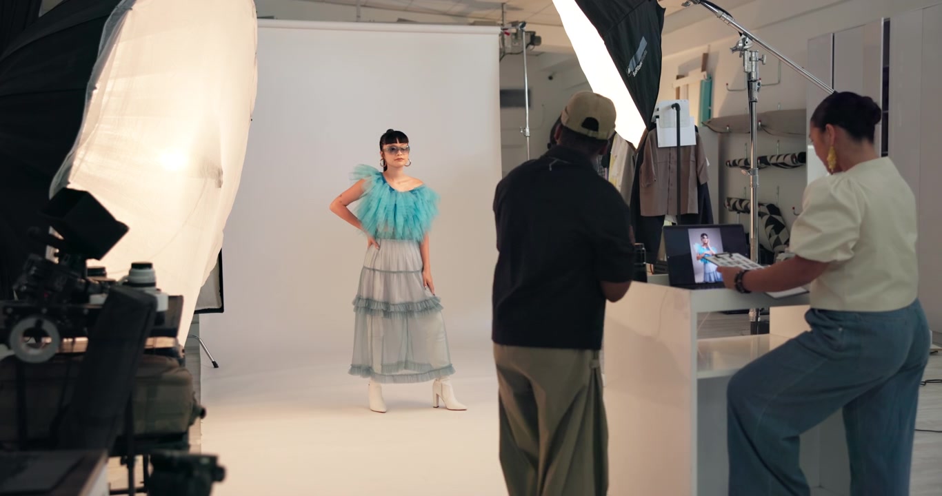 Fotografo di moda che dirige una modella durante un servizio fotografico in studio