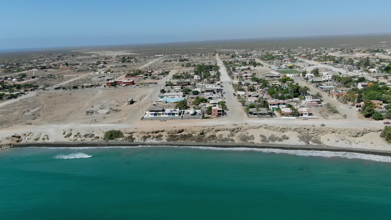 Aerial view move away shot, Scenic view of the town of San Juanico, California Sur, Mexico, waves from the sea in the background