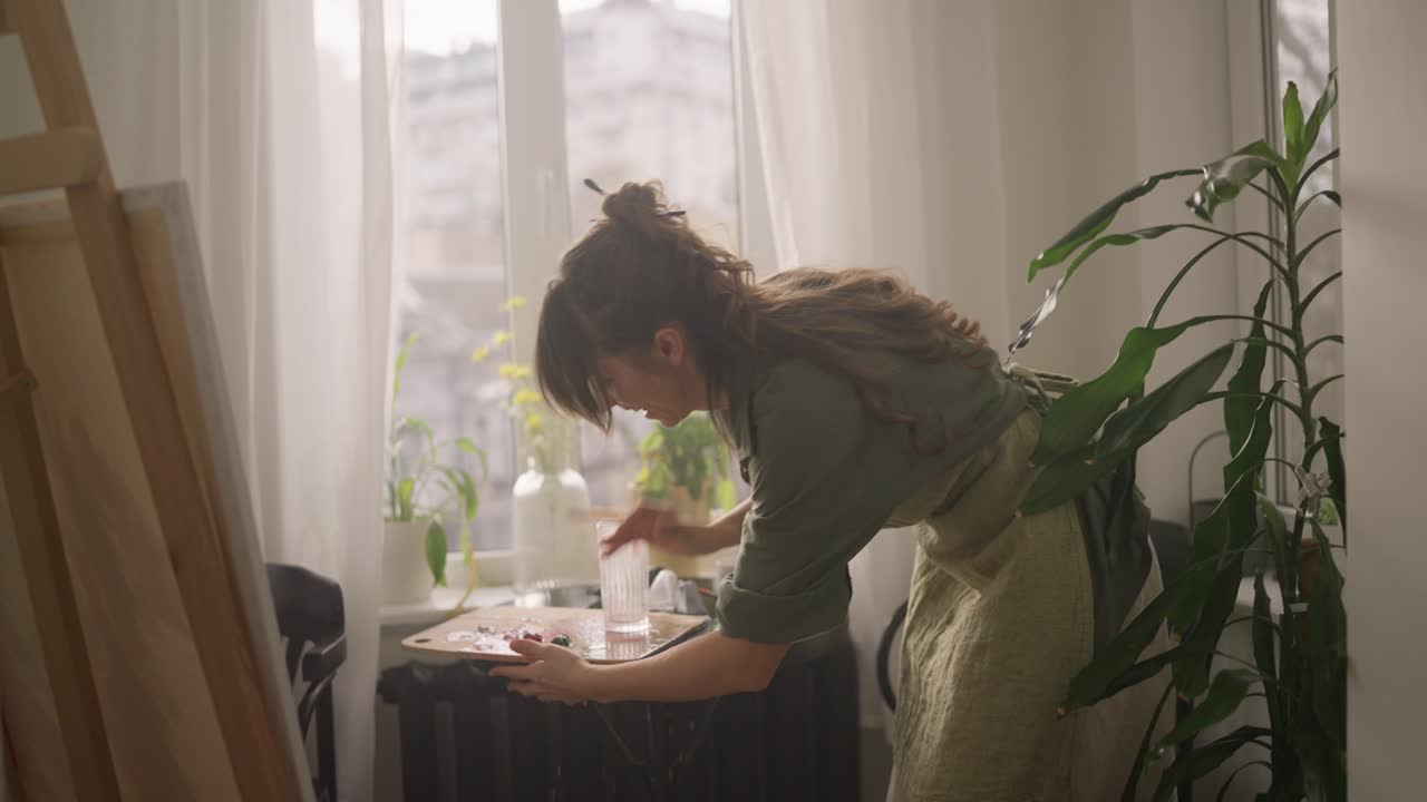 mujer artista pintando en su estudio de casa