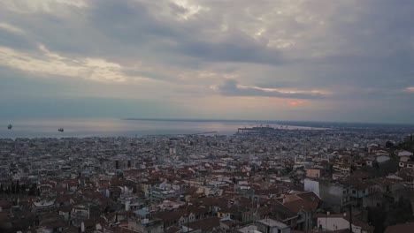 drone flies above old town of thessaloniki on sunset hour with overcast weather, greece