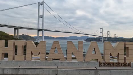 Sign-of-the-shimanami-bridge-with-the-Kurushima-strait-and-kurushima-kaikyo-bridge-in-the-background