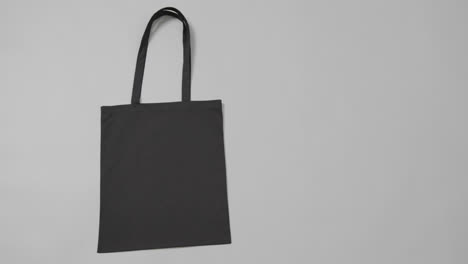 close up of black bag on grey background, with copy space, slow motion