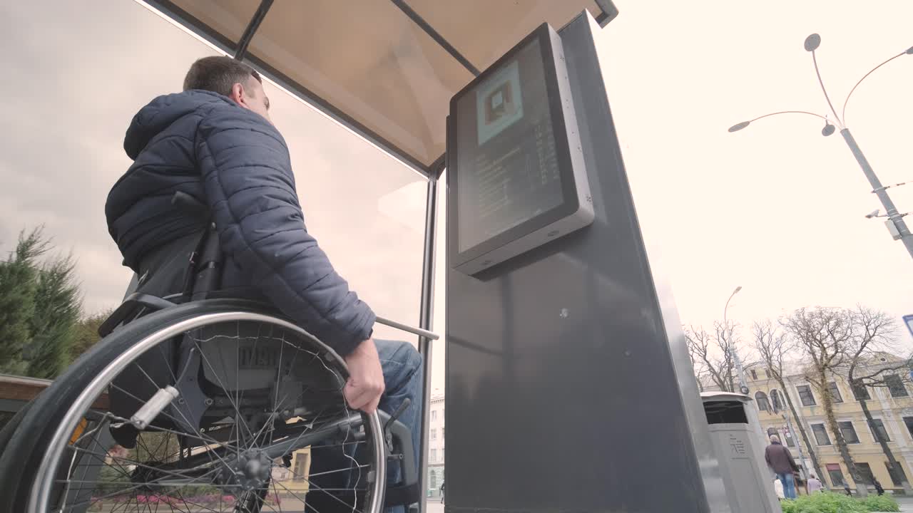persona con discapacidad física que espera un transporte urbano con una rampa accesible
