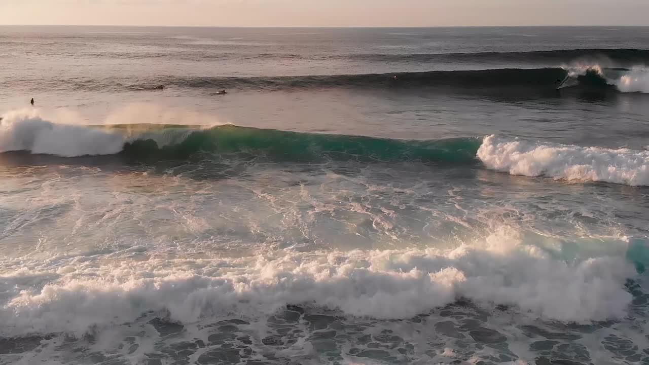 los surfistas observan y luego atrapan varias olas al atardecer en maui, la costa norte de hawai cerca de la playa de ho'okipa