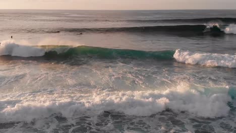 Surfers-watch-then-catch-various-waves-at-sunset-on-Maui,-Hawaii's-north-shore-near-Ho'Okipa-Beach