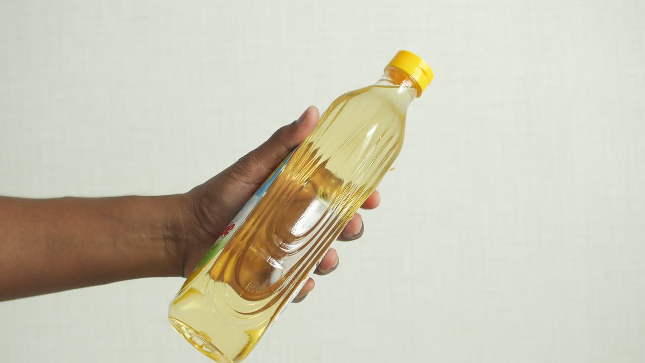 요리 기름 한 병 을 들고 있는 손