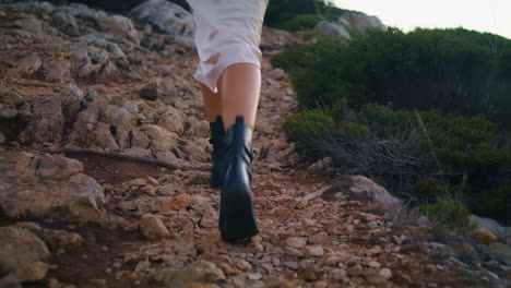 slim woman feet walking cliff back view vertical. unknown model crossing nature