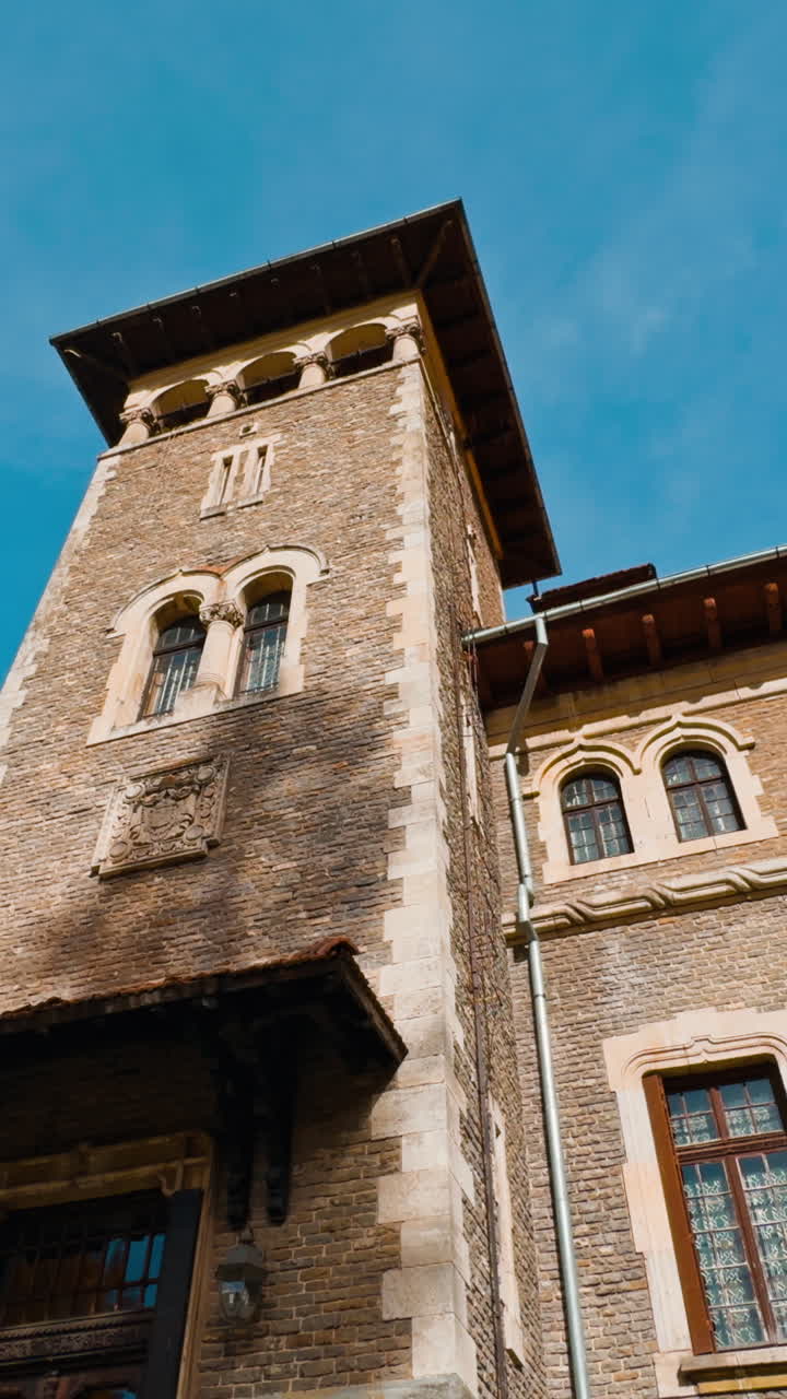 Old brick mansion with tower. Low angle view of the palace located in the mountainous area. Vertical video