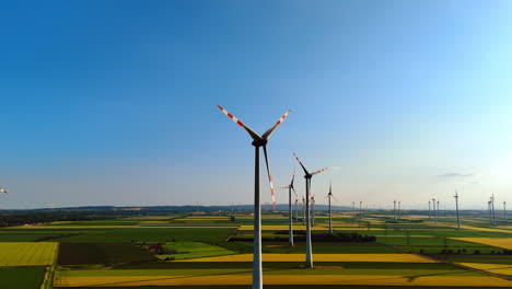 turbines create renewable energy. vast green fields dotted with wind turbines stretch under a clear blue sky, showcasing renewable energy production