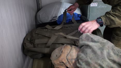 a soldier from the "kfir" or "lion cubs brigade" keeps the costume and tear gas in a bag