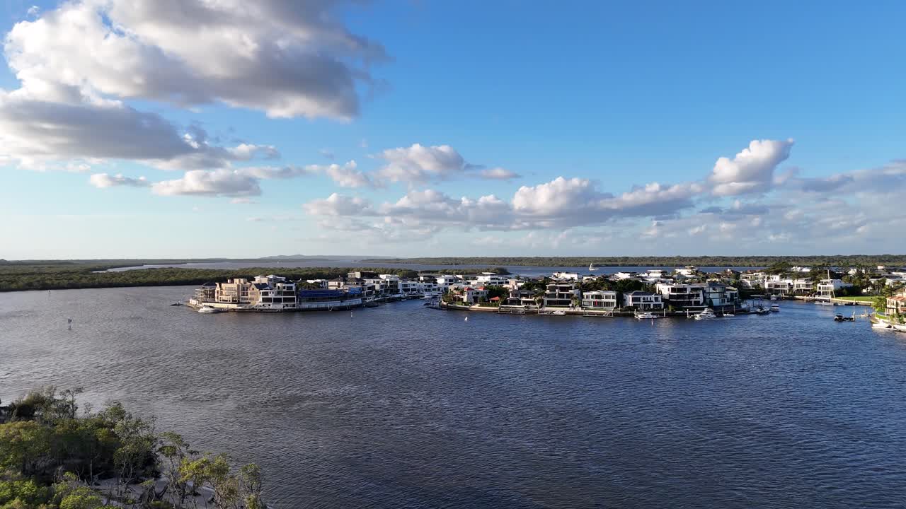 Drone captures serene aerial views of Gold Coast's Broadwater, showcasing coastal architecture and tranquil waters under a vibrant sky