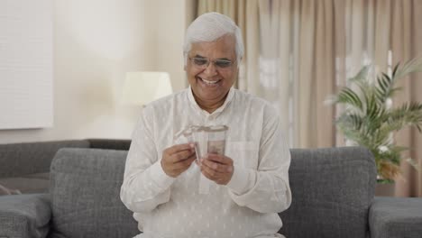 happy indian old man counting money