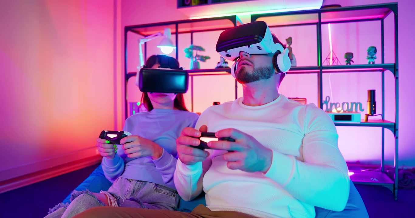 Giovane coppia che gioca a un gioco di realtà virtuale con visori VR.