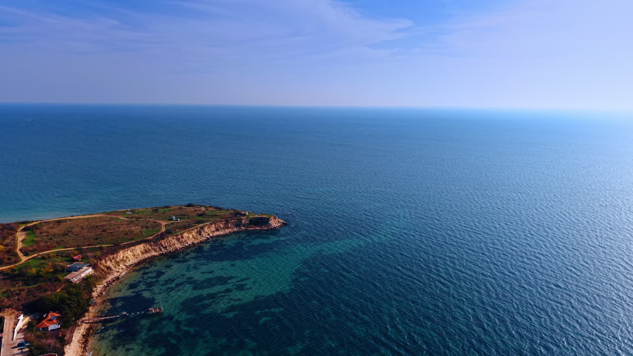 Avvicinandosi alla parte di terra che si protende nel bellissimo e infinito paesaggio marino blu. Alcune case si trovano sulla riva