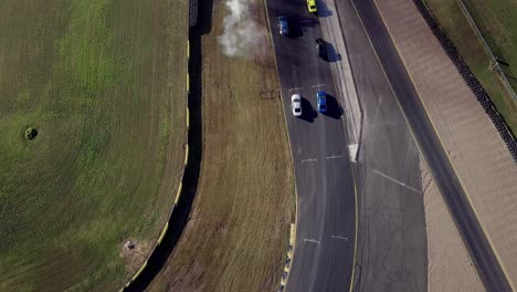 grupo de coches deportivos compitiendo en el parque de deportes automovilísticos de sydney en australia - fotografía aérea de un dron