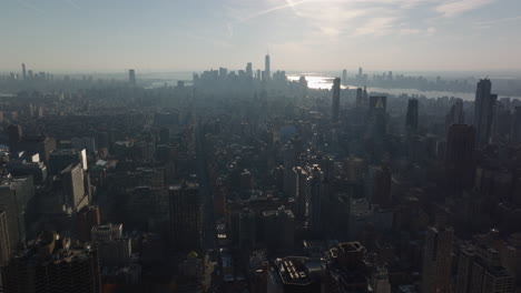Aerial-panoramic-view-of-large-town.-Hazy-view-against-sun.-Silhouettes-of-downtown-skyscrapers-in-distance.-Manhattan,-New-York-City,-USA