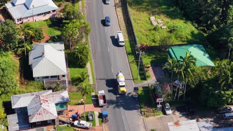 drone footage captures a cement truck driving through a suburban neighborhood with green lawns and residential houses