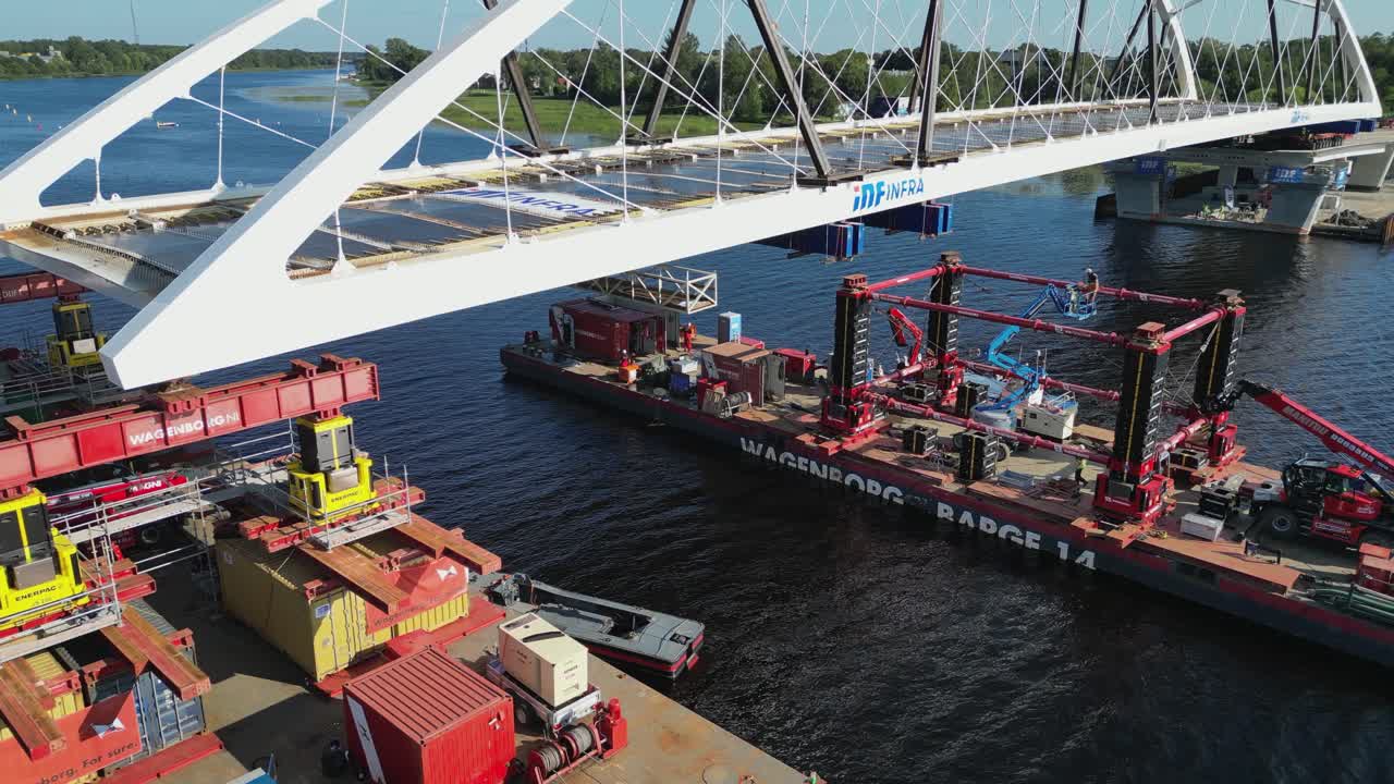 Industrial barge pulls new arch bridge onto supports in Parnu River