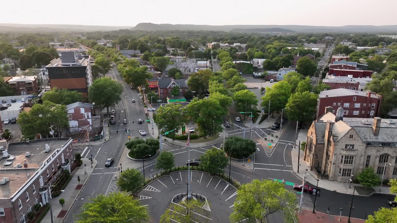 Center Square of Americans town with green trees and flag of USA on flagpole. Sunrises the morning. Historic buildings and churches in New Haven, Connecticut. Aerial Birds Eye shot