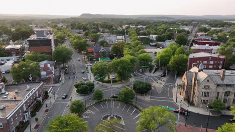 center square of americans town with green trees and flag of usa on flagpole. sunrises the morning. historic buildings and churches in new haven, connecticut. aerial birds eye shot