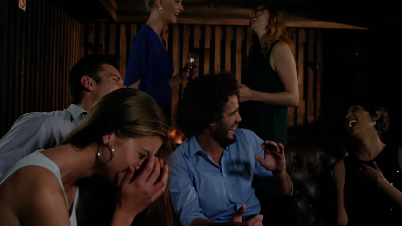 웃는 친구 들 의 그룹 이 술집 에서 재미 를 느끼고 있다