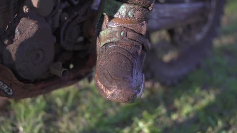 Boots-of-a-motocross-rider-after-an-exhausting-race-on-a-very-muddy-track