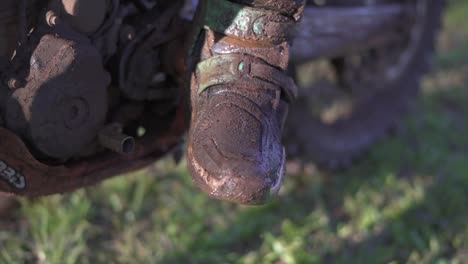 botas de un piloto de motocross después de una carrera agotadora en una pista muy fangosa
