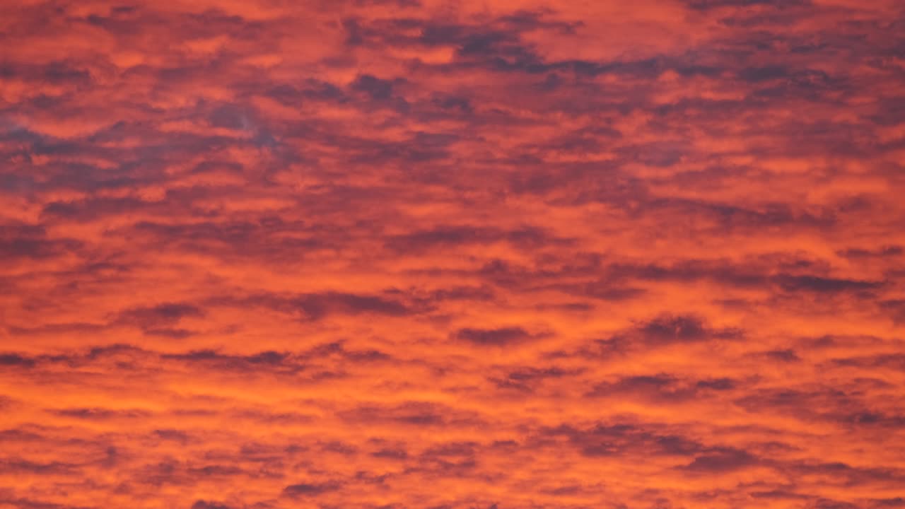 밝고 다채로운 해가 지는 하늘, 생생한 부드러운 구름, 해가 지면으로 퍼지는 빛으로 조명됩니다.