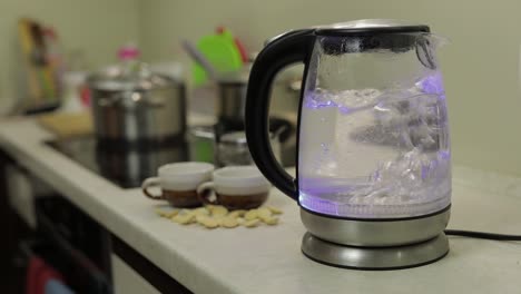 tea kettle with boiling water. tea bags and sugar on the background