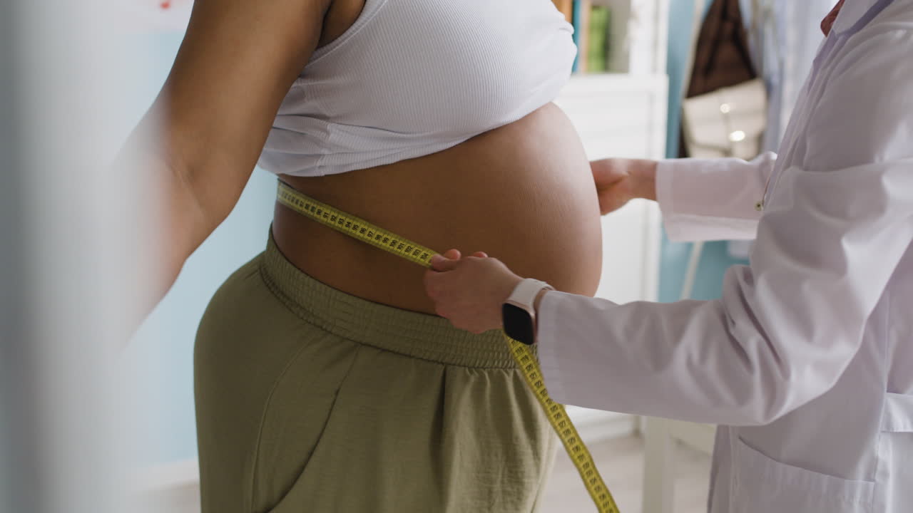 Doctor measuring patient's waist circumference