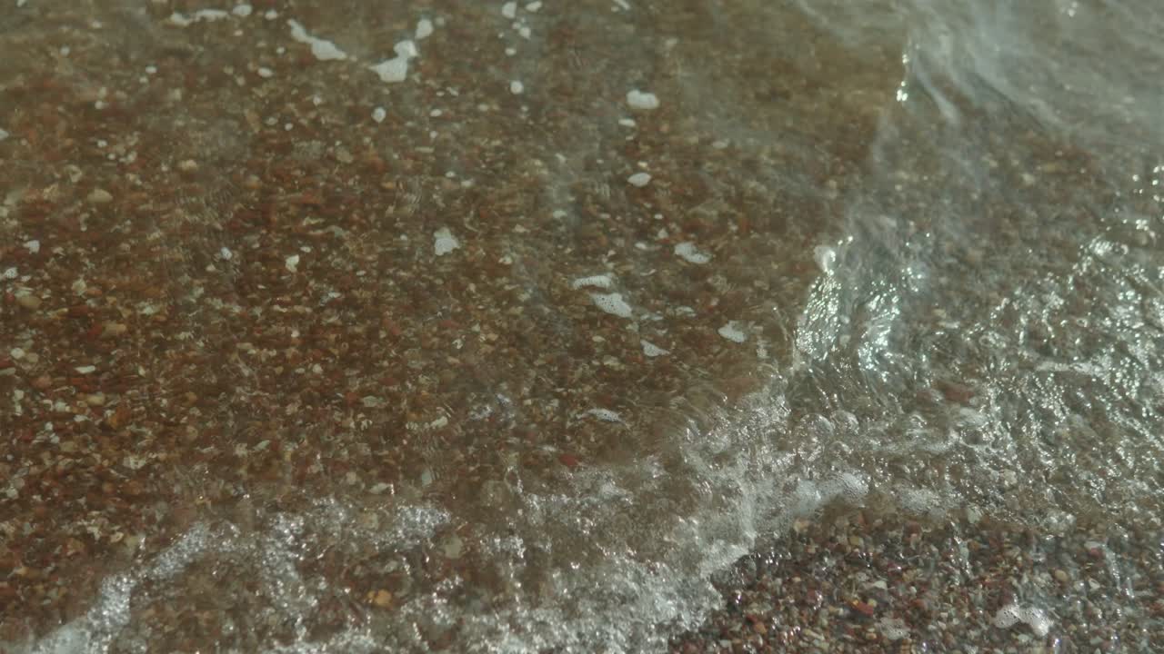 The ocean is calm and the water arriving to the coast is a light blue color