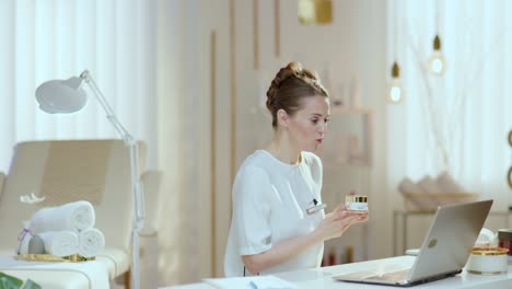 empleada sonriente en un estudio de belleza teniendo una reunión de video