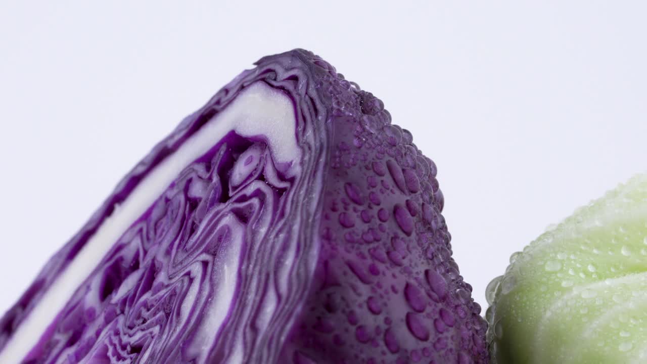 크로스 섹션 매크로는 물방울이 있는 두 개의 미니 이 반의 부분을 촬영합니다. 하나는 색이고 다른 하나는 빨간색입니다. 색 바탕에 고립된 턴테이블에서 천천히 회전합니다. 클로즈업.