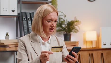 Angry-mad-stressed-businesswoman-trying-to-pay-online-shopping-with-blocked-credit-card-smartphone