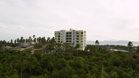 aerial flying towards tallest building on koh samui, thailand