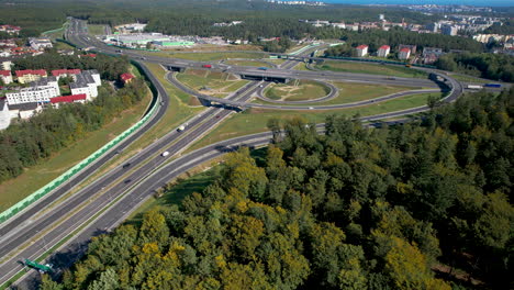 Luftaufnahme-–-Aufstieg-über-Bäume-In-Der-Nähe-Der-Schnellstraße-–-Moderne-Straßen-Für-Sicheren-Transport-Und-Reisen-–-Mehrspurige-Straßenkreuzungen-Und-Kollisionsfreie-Durchfahrten