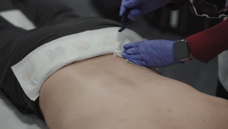 lower back shaving before laser hair removal procedure on man