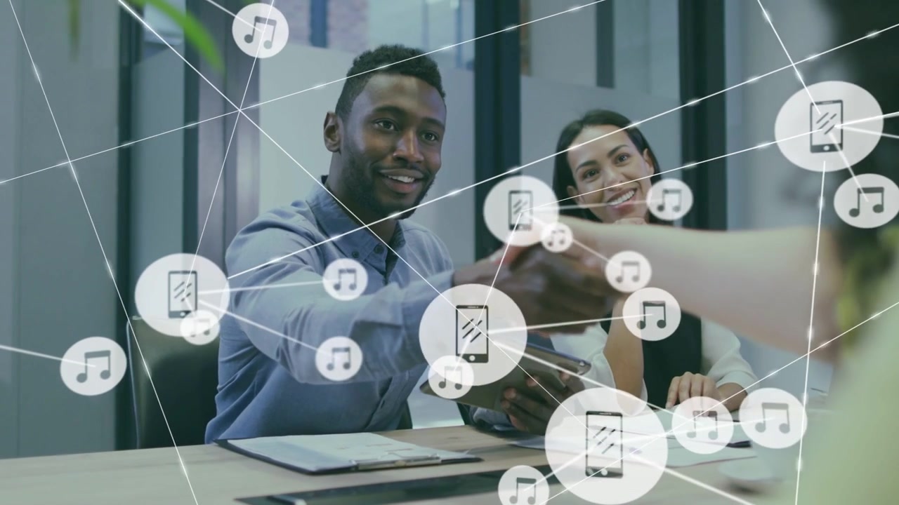 Team holding tablet in business meeting third reaching hand sealing deal phone icons spreading over