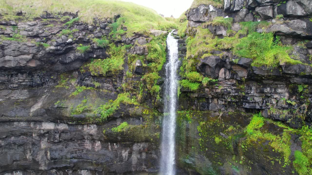 el pueblo de mikladalur y la cascada mientras las gaviotas vuelan alrededor