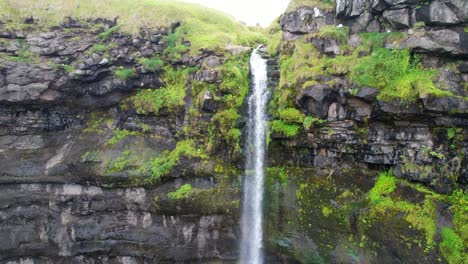 Pueblo-De-Mikladalur-Y-Cascada-Mientras-Las-Gaviotas-Vuelan