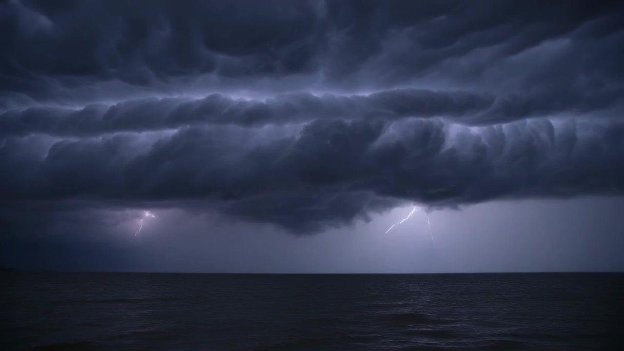 Sending lightning, storm illuminating low shelf cloud at sea, casting brief water reflections