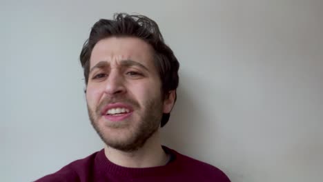 joven estudiante universitario masculino escuchando atentamente mientras mira directamente hacia la cámara