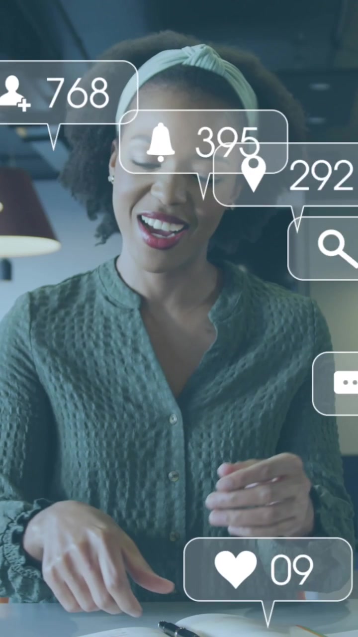Animation of social media icons with numbers over african american businesswoman working at office