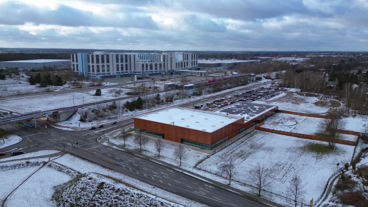 train traveling through a snowy cityscape in segefeld Falkensee. Great aerial view flight static tripod hovering drone