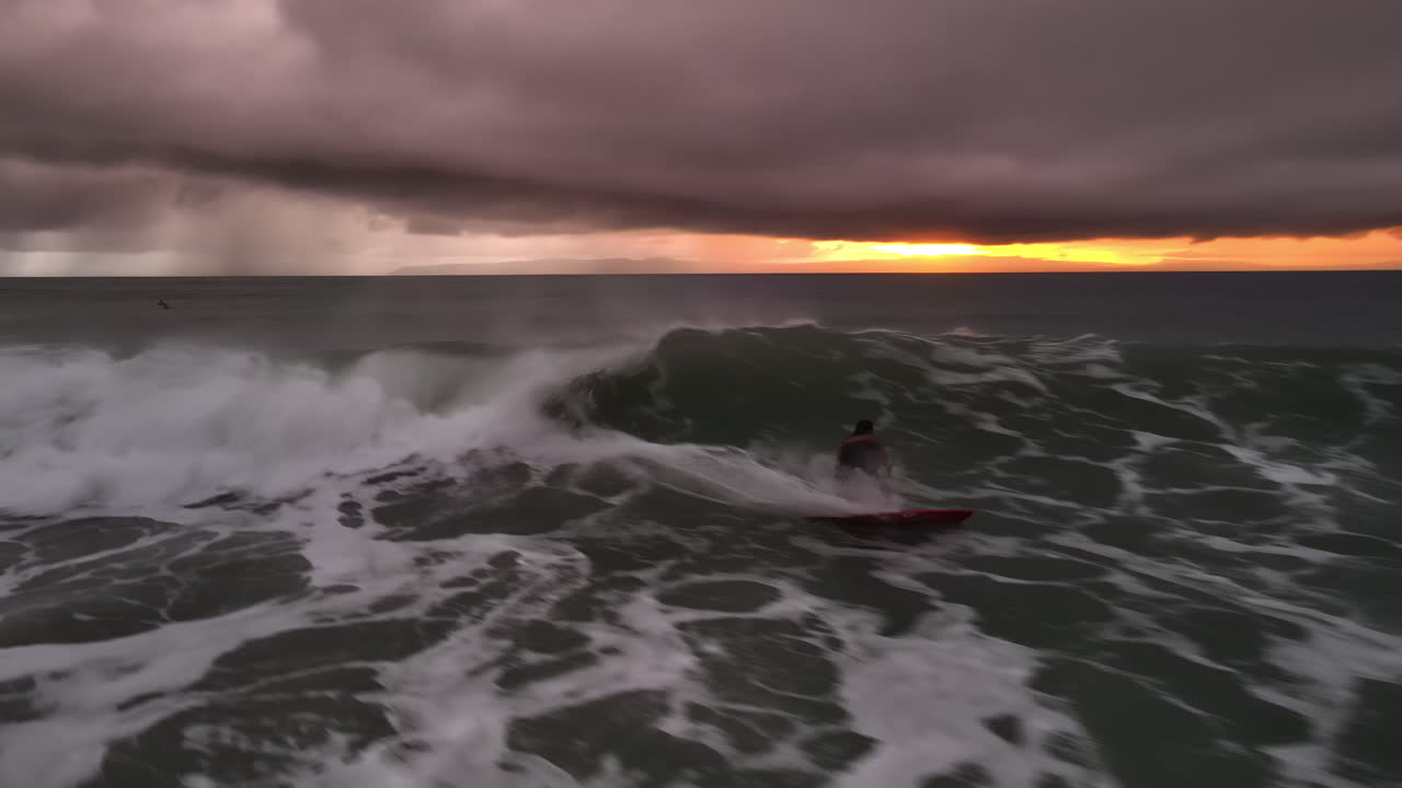 Surfista che cavalca dinamicamente le onde contro il paesaggio marino al tramonto della Costa Rica