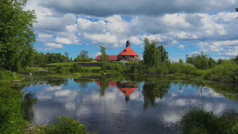 una amplia vista del follaje verde con un lago que refleja toda la imagen en el agua dando una vista celestial en el museo fortaleza korela, rusia