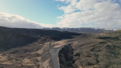 Witness-Icelandic-beauty-via-drone-footage,-See-a-car-navigating-volcanic-terrain-and-rugged-roads-on-an-adventure