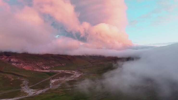 Nuvole sulle montagne e sulla valle durante il tramonto nell'Islanda orientale