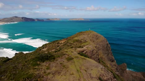 Drohne-Umkreist-Berghügel-Mit-Blick-Auf-Den-Strand-Von-Te-Werahi,-Kap-Maria-Van-Diemen-Und-Die-Insel-Motuopao-Im-Norden-Neuseelands